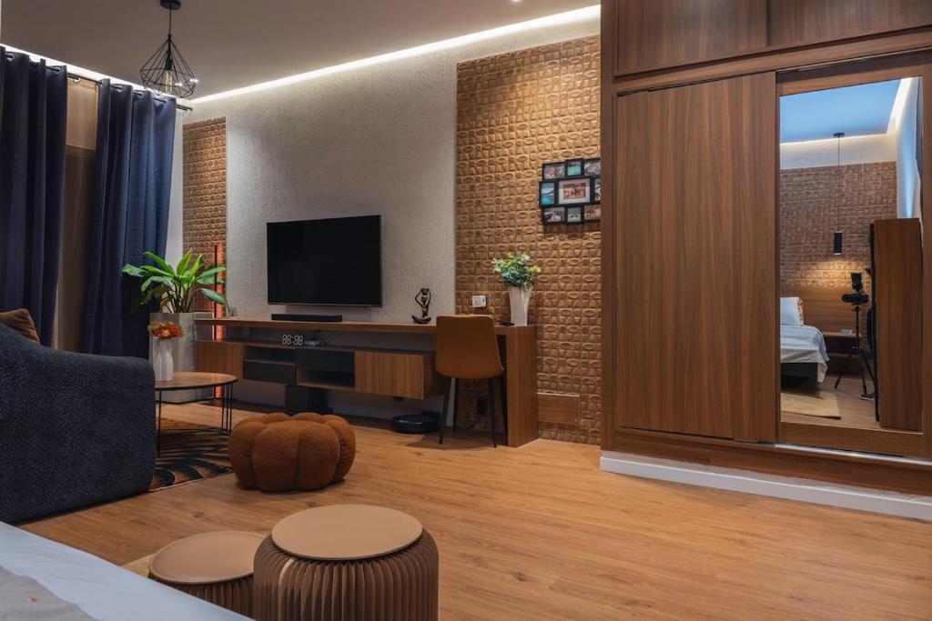 a living room with a television and a living room with a couch at Studio Spacieux et Moderne à Bietry in Abidjan