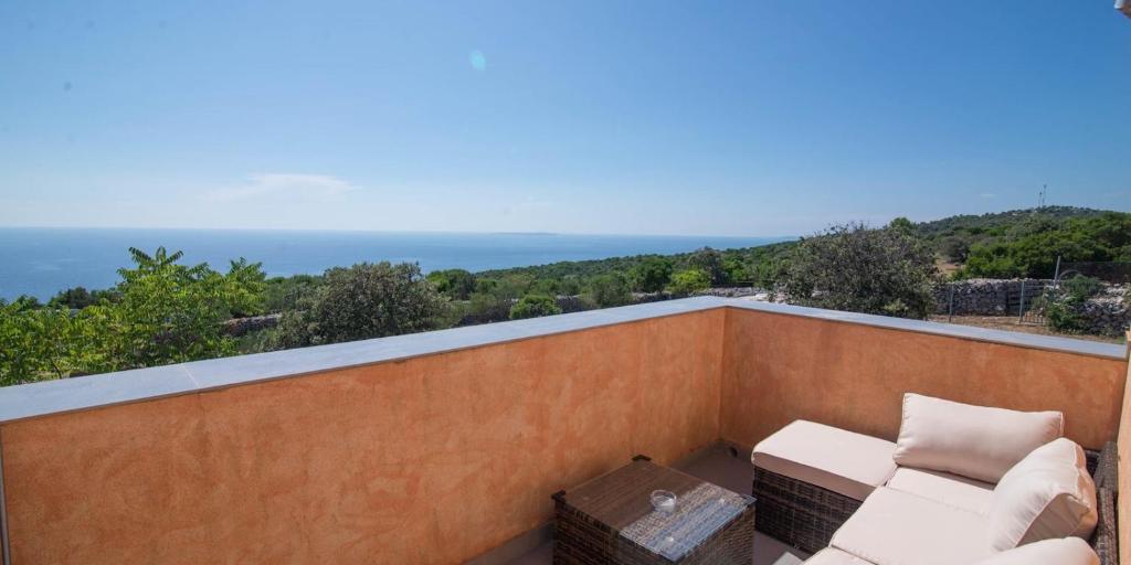 a balcony with a couch and a view of the ocean at Tia in Veli Lošinj