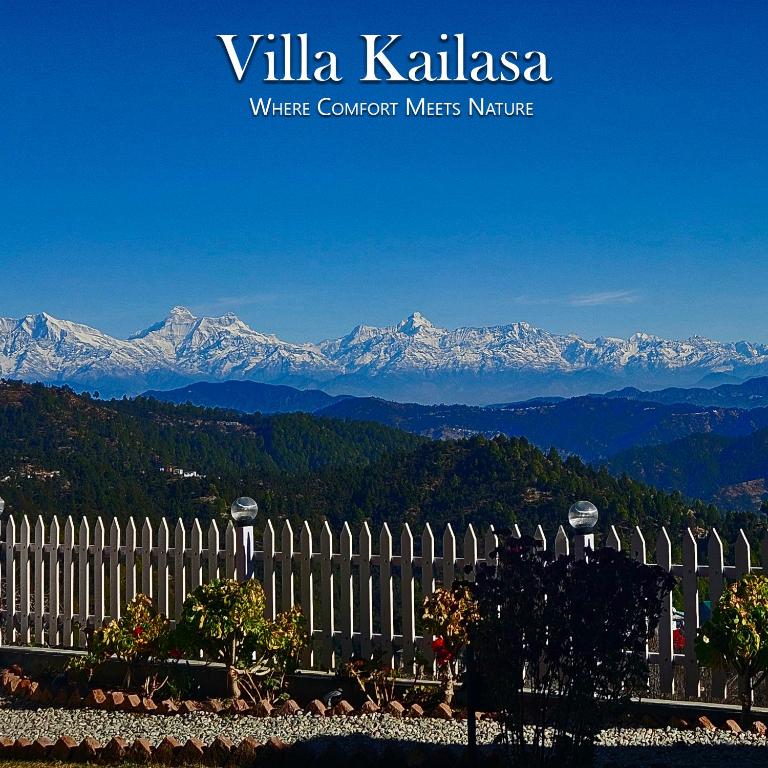 a white fence with mountains in the background at Villa KAILASA in Mukteshwar