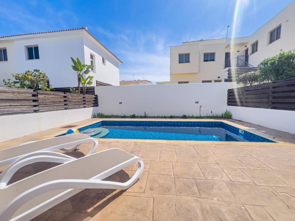 a swimming pool in the backyard of a house at Pernera Seaside Villa - Sun, Sea, Poolside Bliss in Protaras