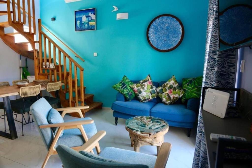 a living room with a blue couch and stairs at Casa Anthos free parking in Chania Town