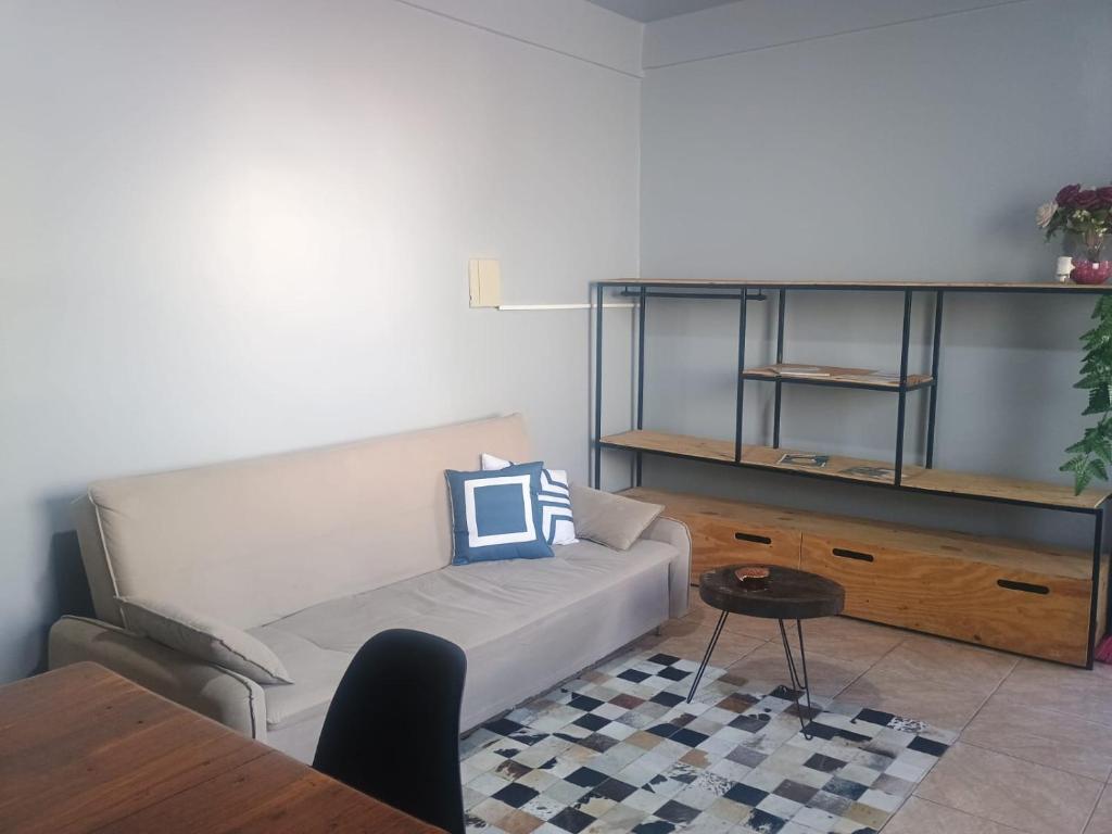 un soggiorno con un divano e un tavolo di Apto Confortável e espaçoso 02 a Cachoeira do Sul