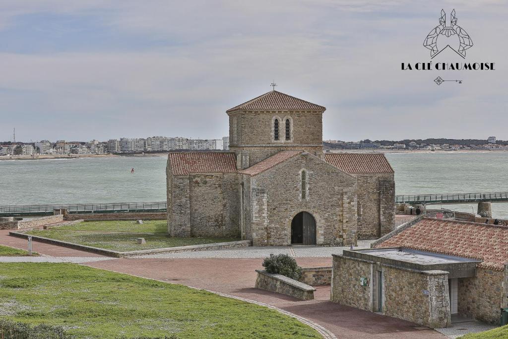 an old stone church next to a body of water at Ancora- Appartement vue mer et place de parking in La Chaume