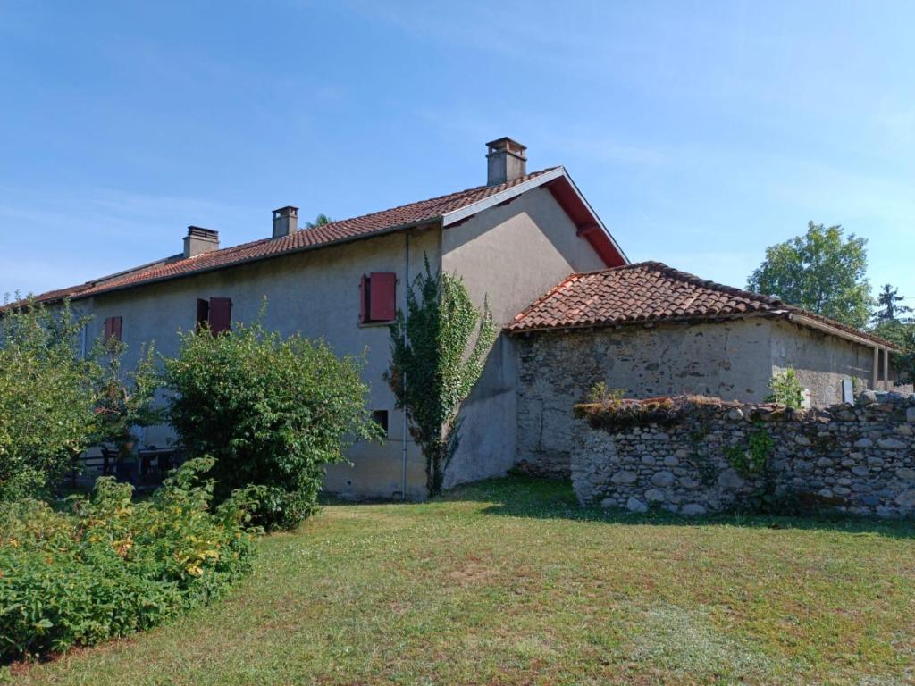 een oud huis met een stenen muur in een tuin bij La Pilote in Ponlat-Taillebourg