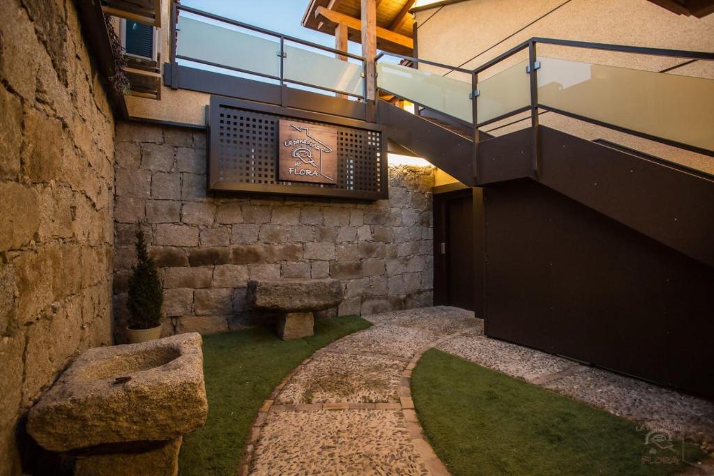 Un edificio con una escalera y un patio con césped. en Apartamentos Turísticos La Panadería de Flora, en Martiherrero