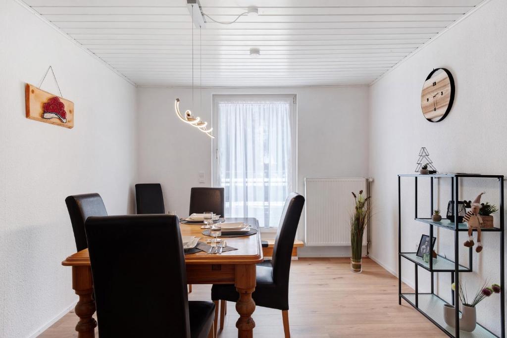 a dining room with a table and black chairs at Auszeit Schwarzwald in Breg