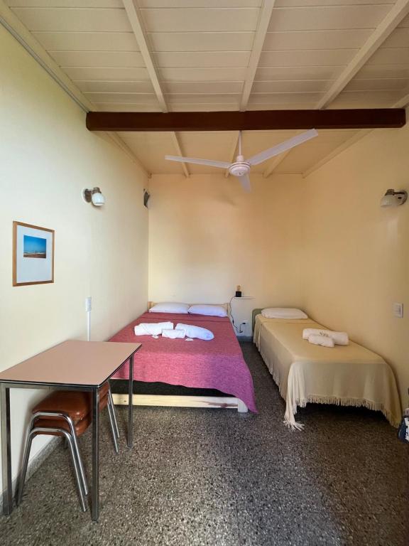 ein Schlafzimmer mit zwei Betten und einem Tisch in der Unterkunft Lo de Sarita Hostería in Necochea