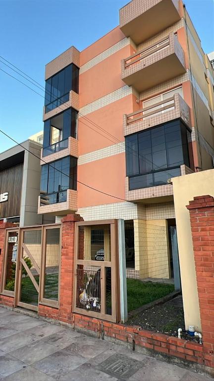 een appartementengebouw met een hek ervoor bij Hyago Monteiro in Capão da Canoa
