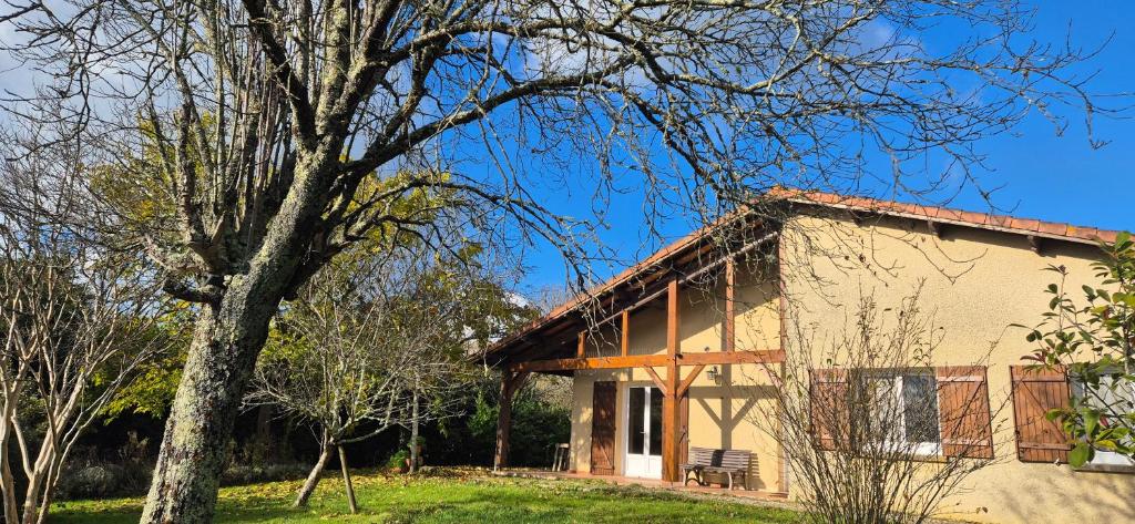 a house with a tree in front of it at Maison de vacances au milieu des vignes in Cazaubon