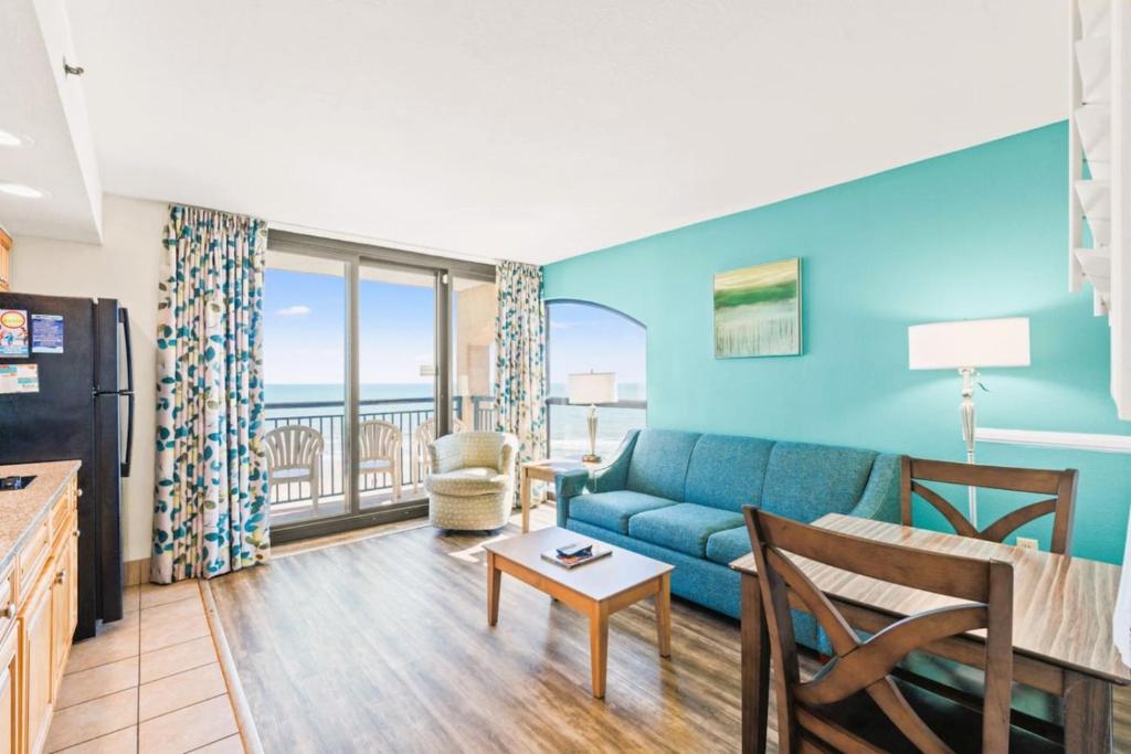 een woonkamer met een bank en een tafel bij Beach Cove Resort Unit 625 Corner Condo with Direct Oceanfront Balcony in Myrtle Beach