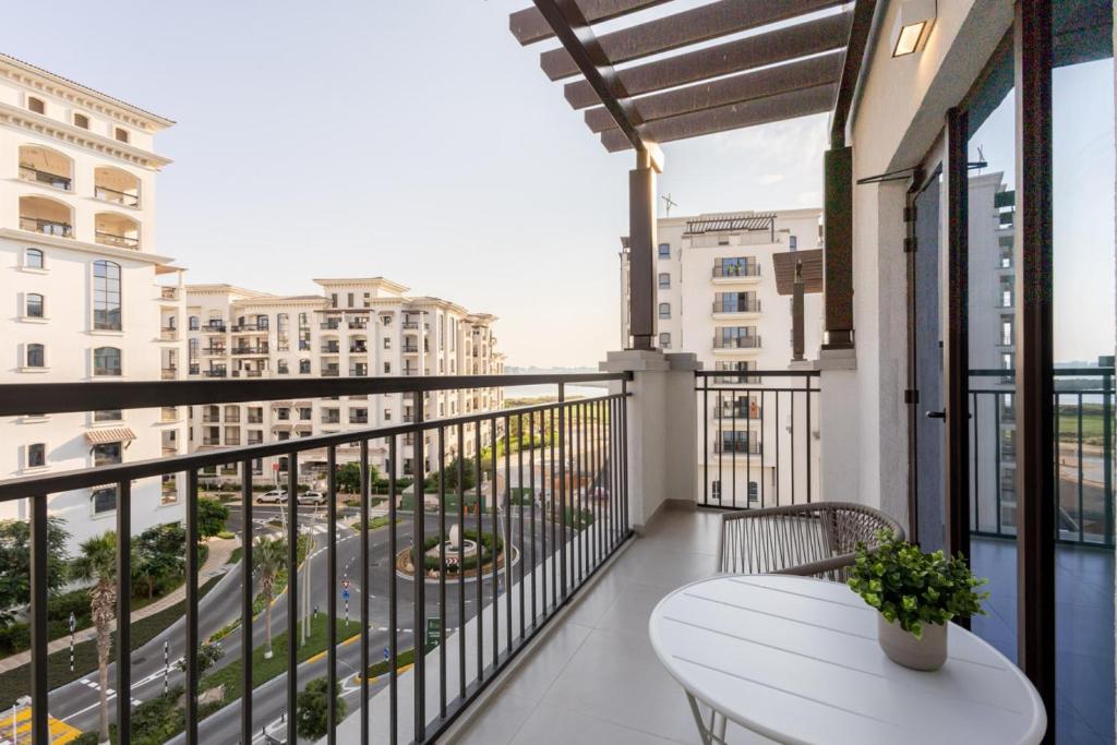 a balcony with a white table and some buildings at Elegant Studio Near Yas Mall and Ferrari World in Yas Island