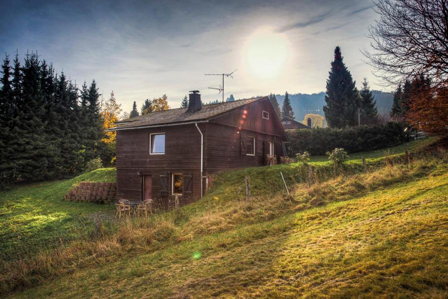 Una casa su una collina con il sole dietro di essa di Ferienhaus Lemmerwiese a Stryck
