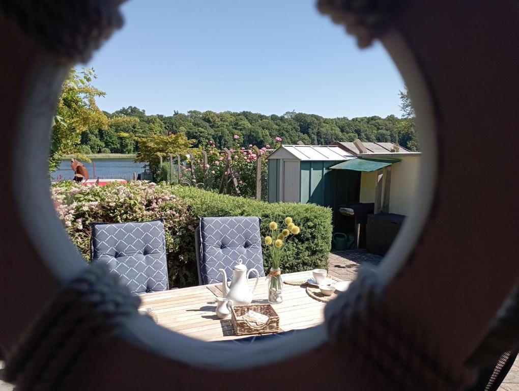 Blick auf einen Tisch und Stühle durch ein Fenster in der Unterkunft Bungalow Seestern in Malchow