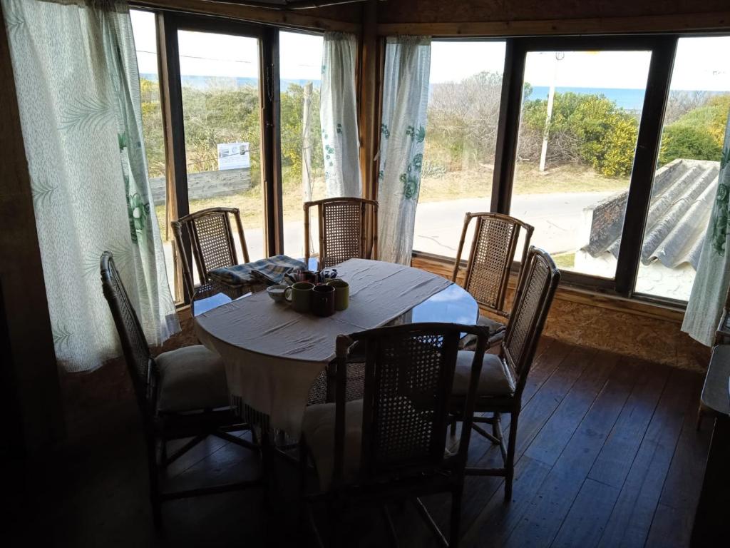 a dining room with a table and chairs and windows at Herminia Sol in La Aguada