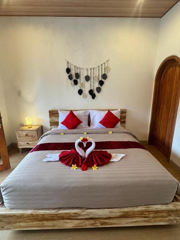 a bedroom with a large bed with red sheets and a heart decoration at Lavanya Loka Balangan in Jimbaran