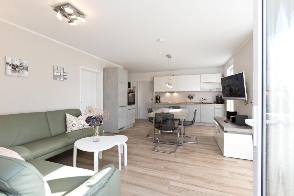 un salon avec un canapé vert et une cuisine dans l'établissement Girlitz Nest, à Röbel