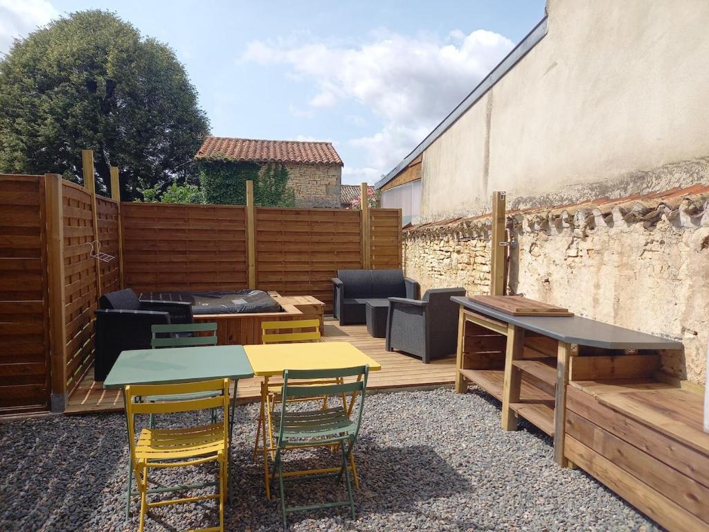 un patio con tavoli, sedie e griglia di Spa Wifi Canal Plus a Rouillé