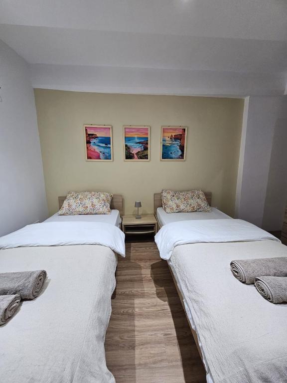 two beds in a room with paintings on the wall at Soulnest Peace bedroom in shared flat in Qbajjar