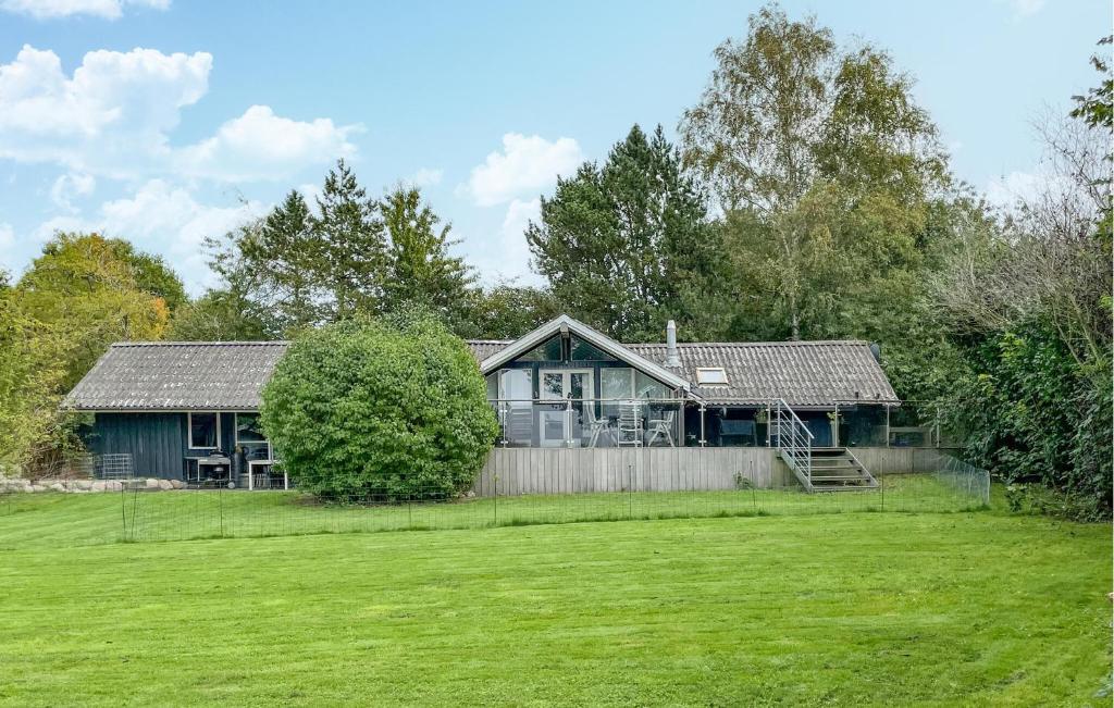 4 Bedroom Gorgeous Home In Tranekær في Stoense: منزل أخضر مع سور وساحة