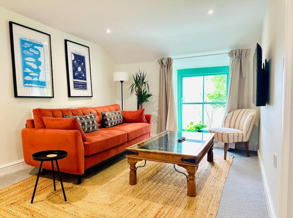 un soggiorno con divano arancione e tavolino da caffè di The Little Egret a Swansea