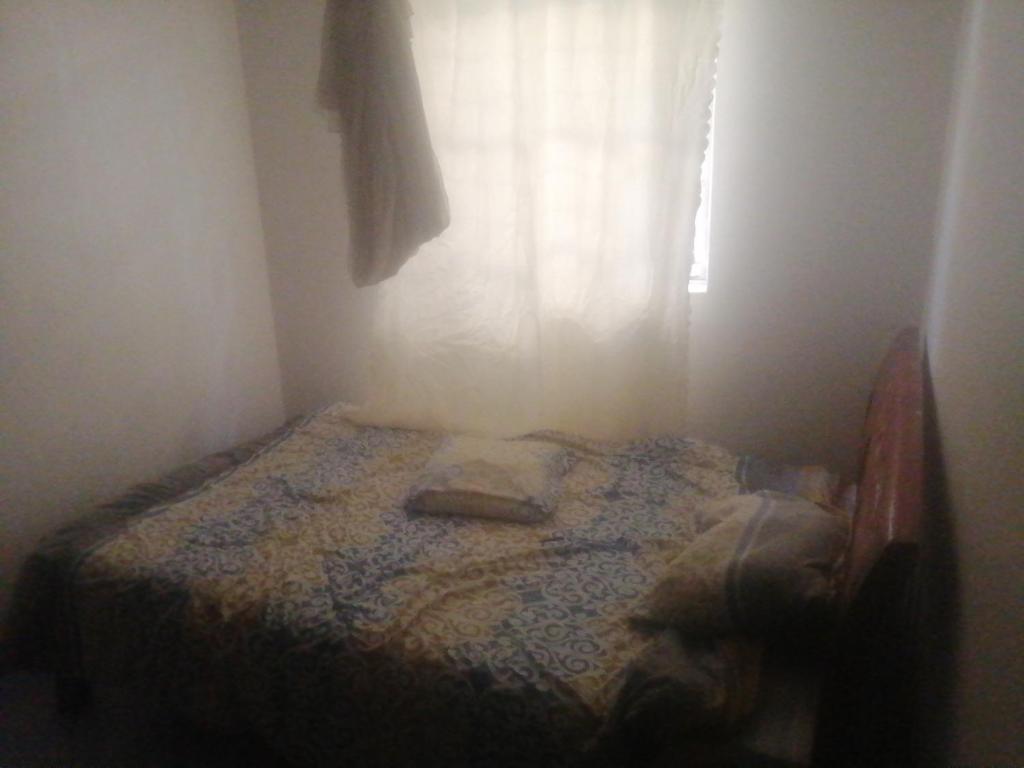 a small bed in a room with a window at Mirema palace in Nairobi