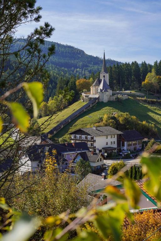 a small town with a church on top of a hill at MyAlpenloft 1 in Deutschgriffen