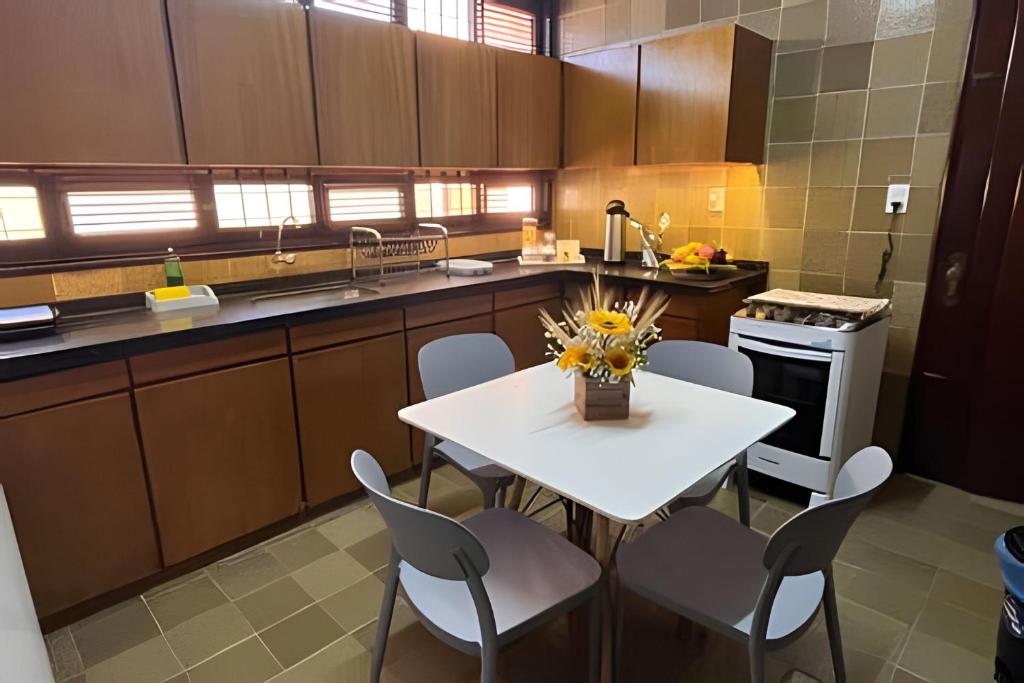 a kitchen with a white table and chairs in it at Studios Casamarela in Mossoró