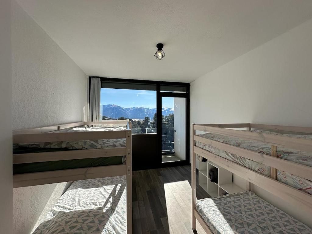 zwei Etagenbetten in einem Zimmer mit Fenster in der Unterkunft Family retreat in the middle of nature Font Romeu in Égat