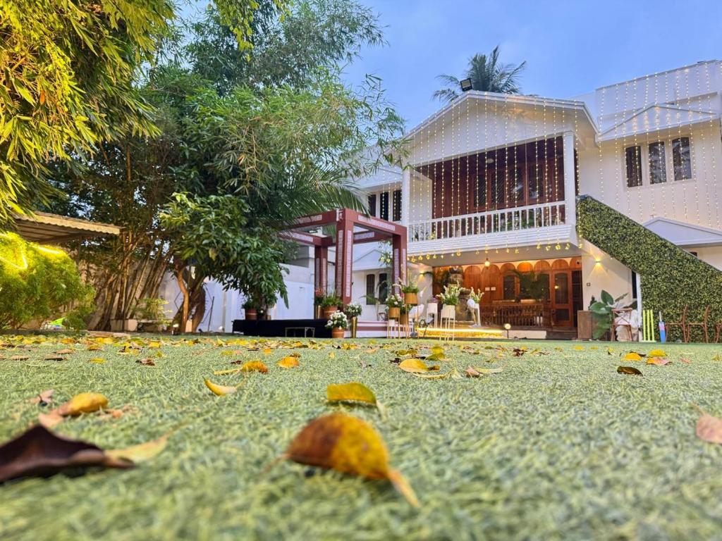 a house with leaves on the ground in front of it at Retreat by Hexa 4 Bedroom with pool and Event Space in Trivandrum