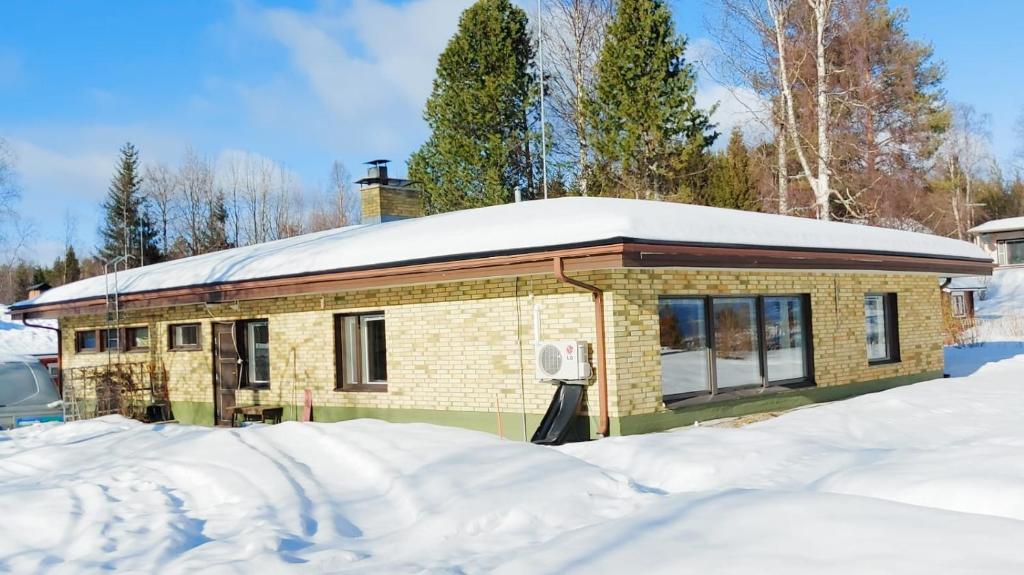 una casa con un tetto innevato nella neve di Aurora house a Rovaniemi