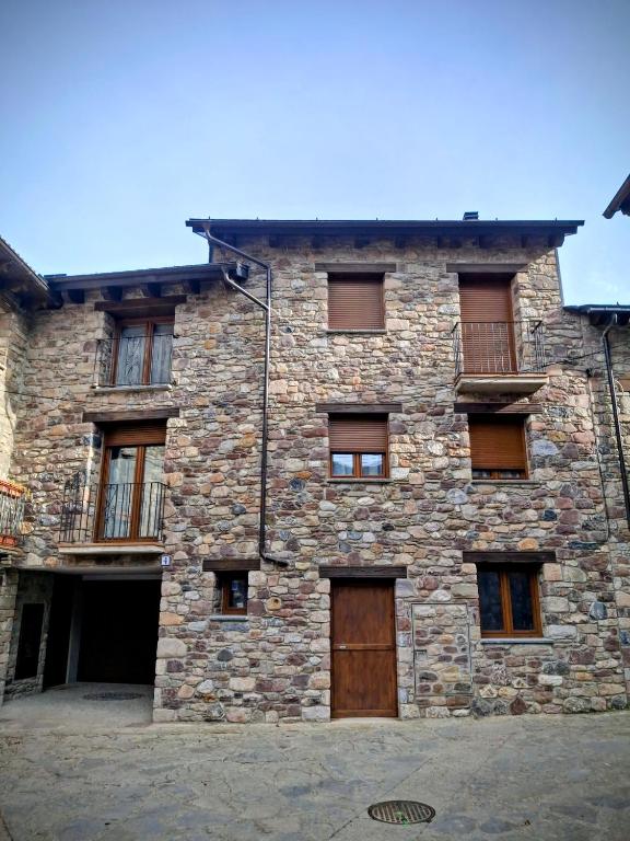 an old stone building with a wooden door at Apartamentos Casa Domec in Castejón de Sos