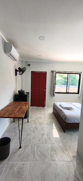 Schlafzimmer mit einem Bett und einer roten Tür in der Unterkunft Modern Bungalows in Ko Lanta Yai