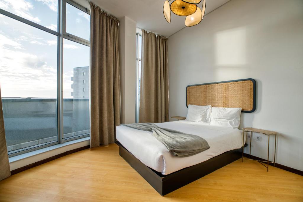 a bedroom with a bed and a large window at Apartment T1 - Porto in Porto