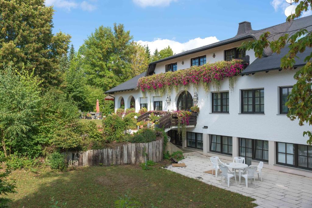 a white house with a table and chairs in the yard at Landhaus Deuber in Weismain