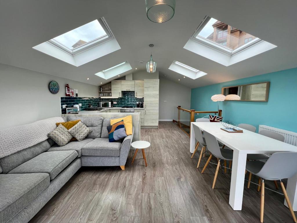 un soggiorno con un divano e un tavolo di Seaside Escape in Westward Ho! 3-Bed Family Holiday Home with Sea Views a Westward Ho