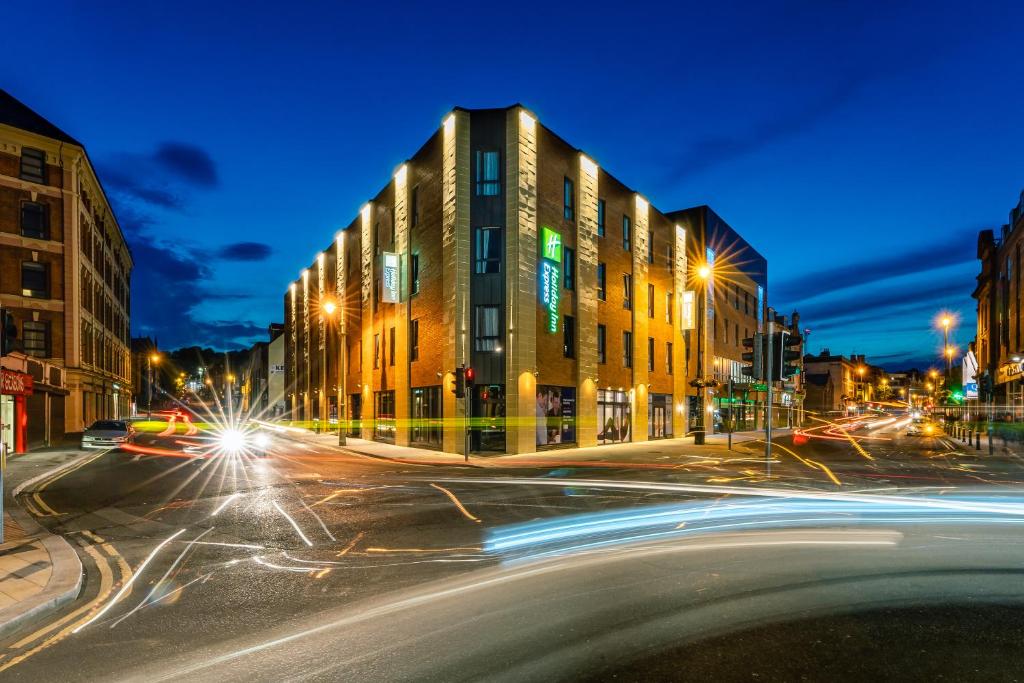 uma rua da cidade à noite com um edifício e luzes de rua em Holiday Inn Express - Derry - Londonderry by IHG em Derry Londonderry