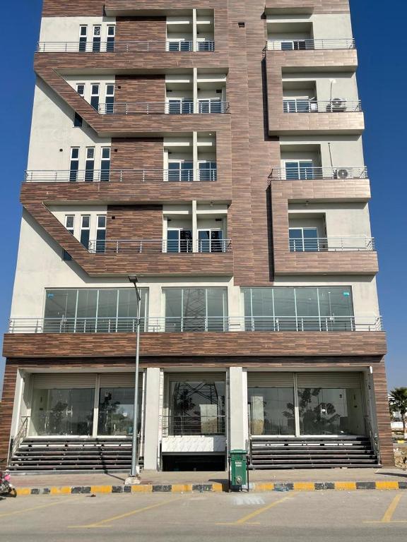 a tall brick building with windows in front of it at Royal Apartments-One Bed Apartments in Islamabad
