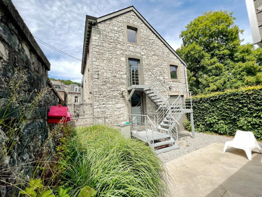 a stone house with a staircase in front of it at L'atelier de Durbuy in Durbuy