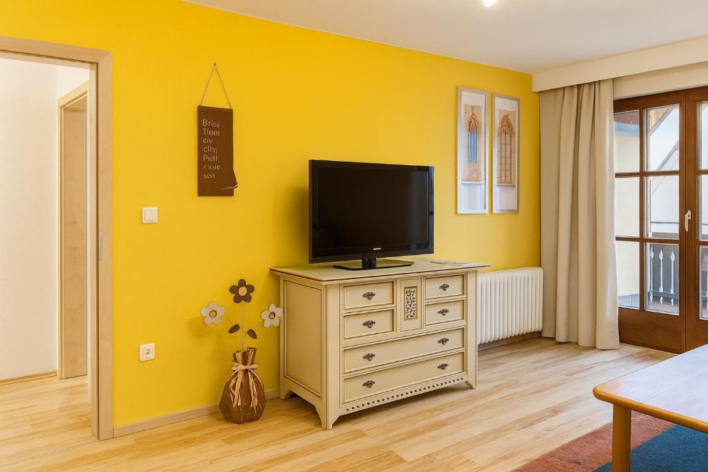 a living room with a television on a dresser at Fewo Mainau in Unteruhldingen