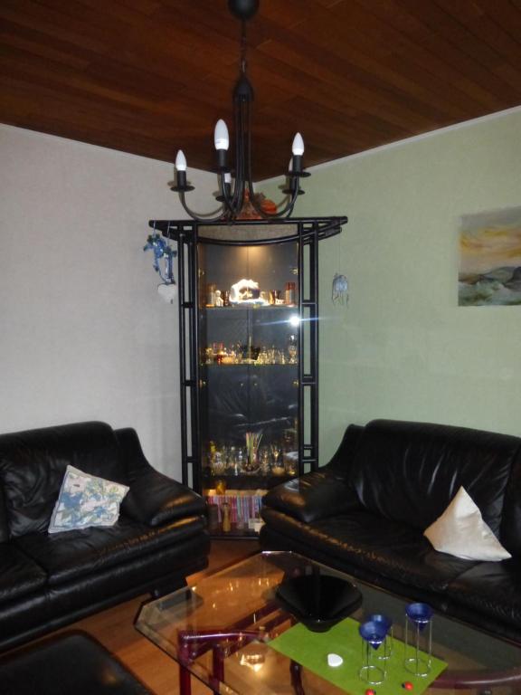 ein Wohnzimmer mit zwei schwarzen Ledersofas und einem Tisch in der Unterkunft Ferienwohnung Bruni in Birresborn