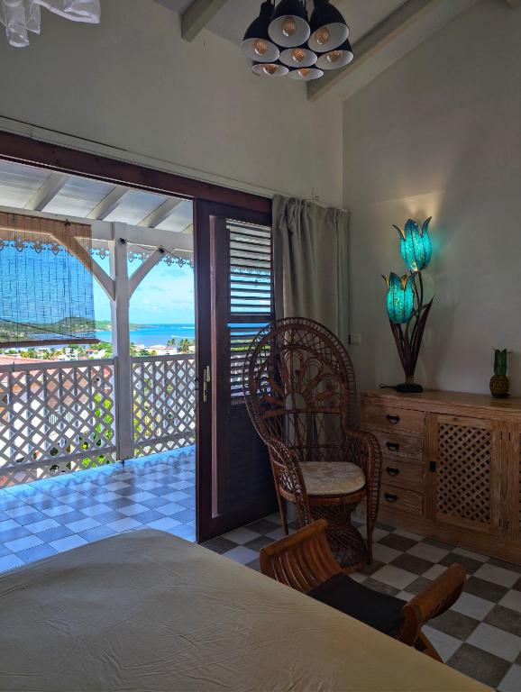 a bedroom with a bed and a view of the ocean at Studio Frangipani dans Villa Fleurs des Iles in Le Vauclin