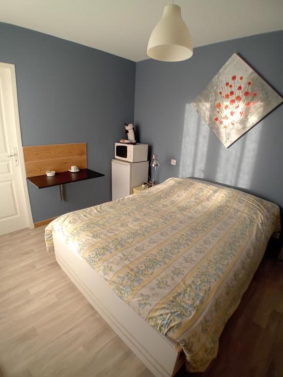 ein Schlafzimmer mit einem Bett und einem Kühlschrank. in der Unterkunft Chambre d'hôtes Gimont in Gimont