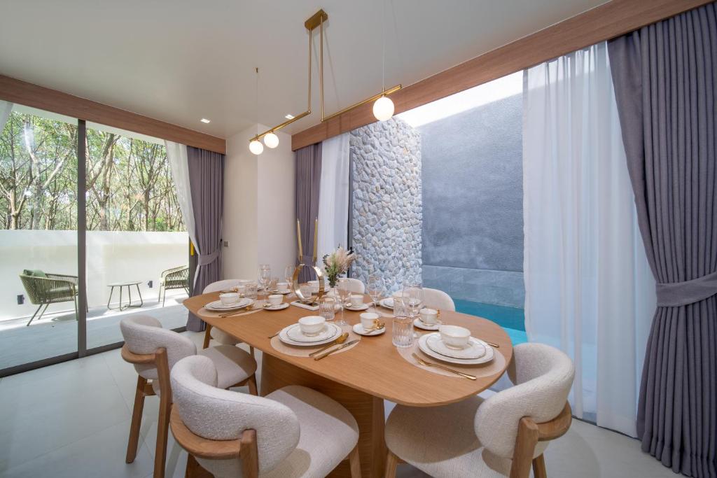 a dining room with a wooden table and chairs at 竹光别院 Bamboo Radiance Villa in Ban Thalat Choeng Thale