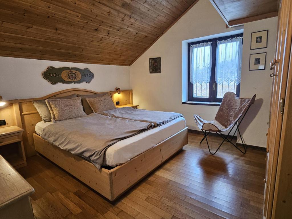 a bedroom with a bed and a chair in it at San Rocco Lodge in Livigno