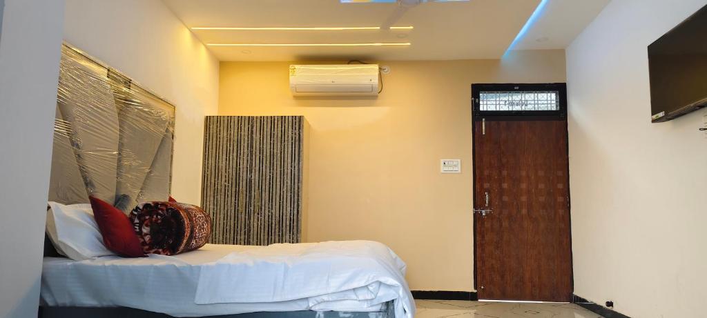 a bedroom with a bed and a door in a room at Dev Guest House in Aklera