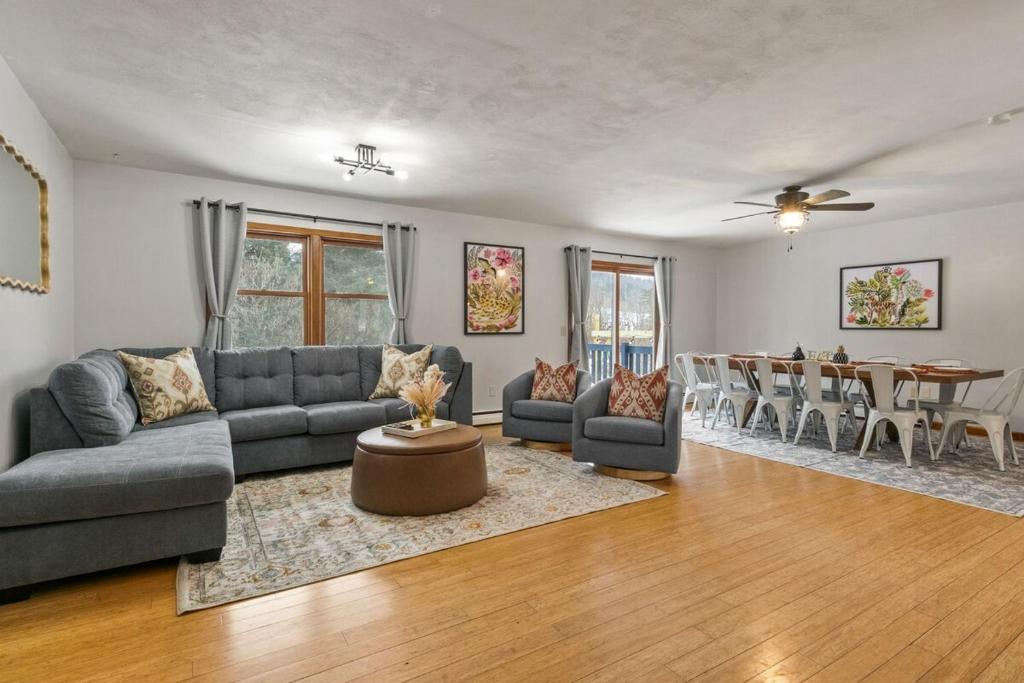 a living room with a couch and a table at Dual Home Retreat! Walk Between Both! Sleeps 28 in Newfield