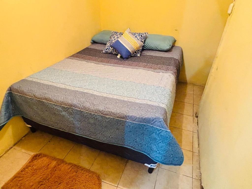 ein kleines Bett mit Kissen darauf in einem Zimmer in der Unterkunft Arianas Place 2 in Huehuetenango