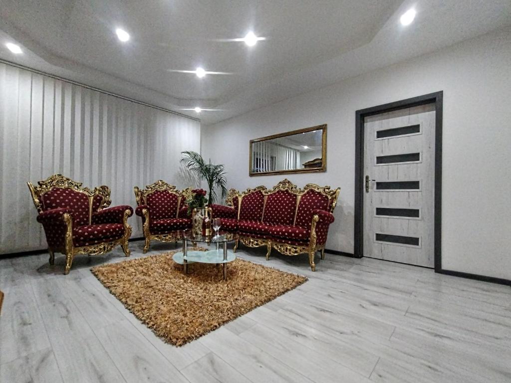 a living room with chairs and a table and a door at Apartmán Sofia Centrum in Michalovce