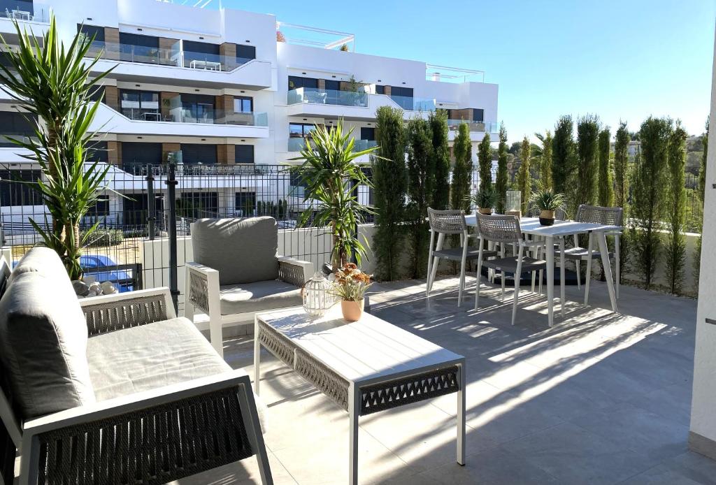 een patio met stoelen en tafels en een gebouw bij Xava Dreams Aire in Villacosta