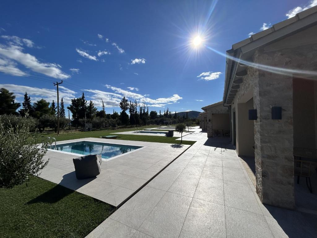 Olive Grove Villas Galaxidi في غالاكسيدي: حمام سباحة في ساحة بجوار مبنى